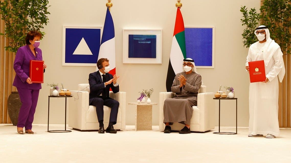 French President Macron (C-L) and Abu Dhabi’s Crown Prince Mohammed bin Zayed al-Nahyan (C-R) are presented by French Culture Minister Roselyne Bachelot (L) and an Emirati official with a bilateral agreement signed by France and the United Arab Emirates in the Gulf emirate of Dubai on December 3, 2021. (Thomas Samson/AFP)