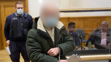 Defendant Anwar R. (R) waits in a courtroom of the Higher Regional Court in Koblenz, western Germany, for the start of another trial session on December 2, 2021. Anwar R. is accused of overseeing the murder of 58 people and the torture of 4,000 others at the Al-Khatib detention centre in Damascus between April 29, 2011 and September 7, 2012. He was put on trial in April 2020 along with another lower-ranking defendant, Eyad al-G., accused of helping to arrest protesters and deliver them to Al-Khatib. Al-Gharib was sentenced to four and a half years in prison in February 2021 for complicity in crimes against humanity, in the first verdict worldwide over torture by Syrian President Bashar al-Assad's government. (Photo by Thomas Frey / POOL / AFP) / GERMAN COURT REQUESTS THAT THE FACE OF THE DEFENDANT MUST BE MADE UNRECOGNISABLE - GERMAN COURT REQUESTS THAT THE FACE OF THE DEFENDANT MUST BE MADE UNRECOGNISABLE