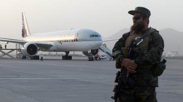 FILE PHOTO: A member of Taliban security forces stands guard in front of a Qatar Airways airplane boarding passengers at the international airport in Kabul, Afghanistan, September 10, 2021. WANA (West Asia News Agency) via REUTERS ATTENTION EDITORS - THIS IMAGE HAS BEEN SUPPLIED BY A THIRD PARTY./File Photo