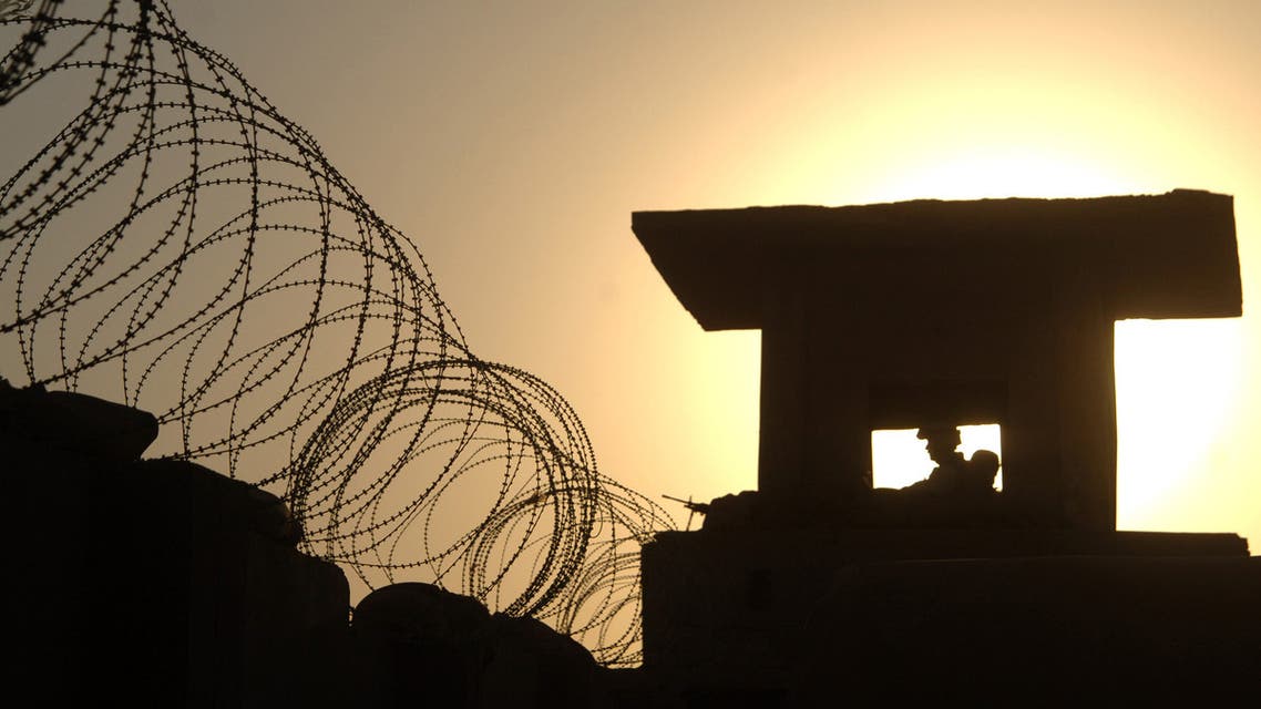 The sun silhouettes Army Spc. Grant Richardson as he stands guard in a tower at Forward Operating Base Hieder in the Ninewa Province town of Rabi'ah, Iraq in this handout photo released July 8, 2005. (Reuters)