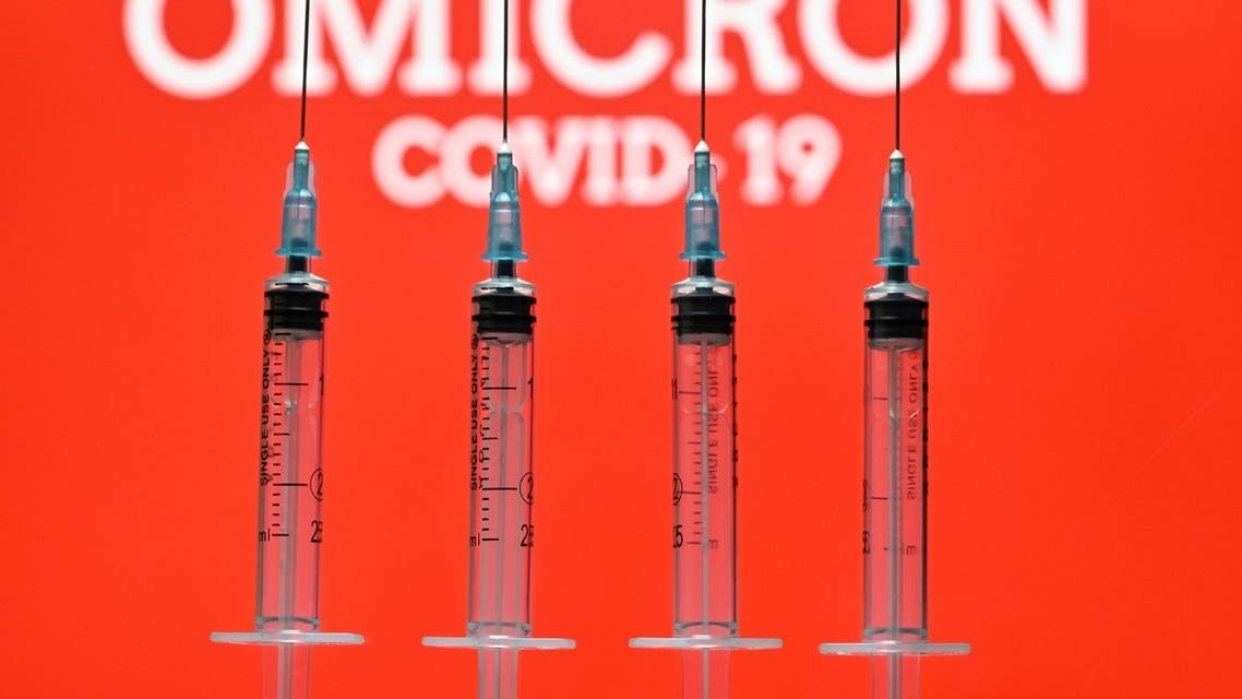 An illustration picture taken in London on December 2, 2021 shows four syringes and a screen displaying the word 'Omicron', the name of the new covid 19 variant. (AFP)