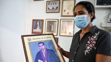 Nilushi Dissanayake the wife of Sri Lankan factory manager holds her husband’s graduation photograph at her residence in Ganemulla near Colombo on December 5, 2021. (Ishara S. Kodikara/AFP)