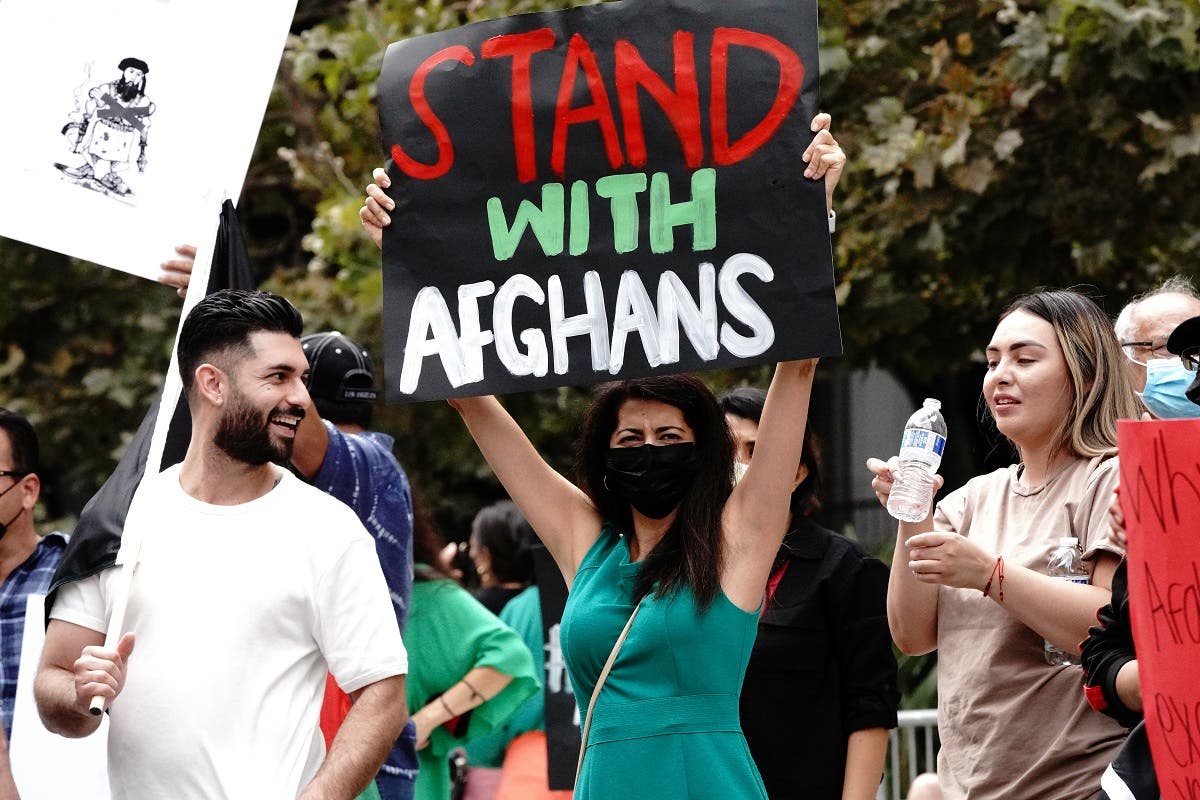 Paris Sharifie, an Afghan-American immigrant originally from Herat, displays a placard reading Stand With Afghans at a rally against the Taliban in Los Angeles, Aug. 21, 2021. (Reuters)