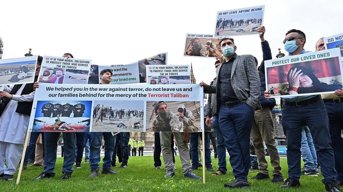 Demonstrators, including former interpreters for the British Army in Afghanistan, hold placards as they protest opposite the Houses of Parliament in London on August 18, 2021, following the withdrawal of troops and the resumption of power by the Taliban in Kabul. (Glyn Kirk/AFP)