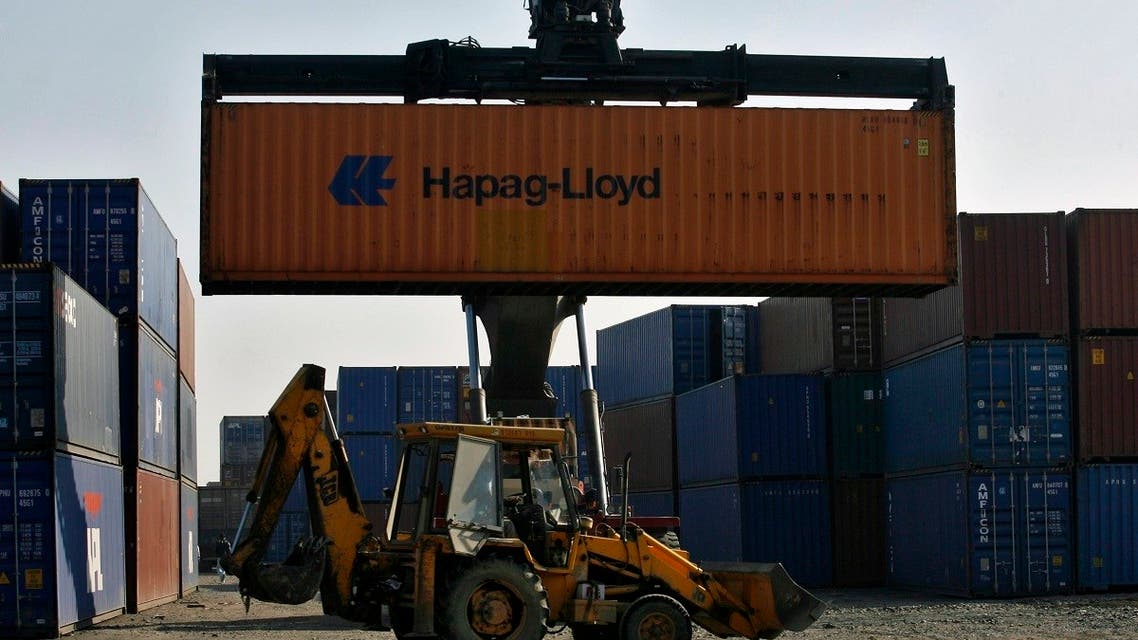 A skip loader drives past a container stacker at Thar Dry Port in Sanand in the western Indian state of Gujarat. (Reuters)