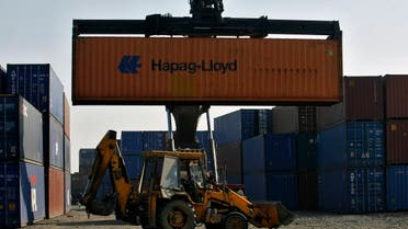 A skip loader drives past a container stacker at Thar Dry Port in Sanand in the western Indian state of Gujarat. (Reuters)