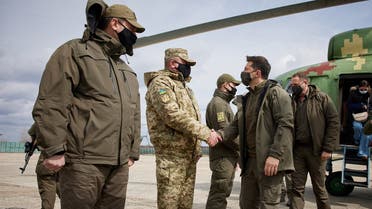 Ukraine’s President Volodymyr Zelenskiy shakes hands with a serviceman during his working trip to the frontline with Russian-backed separatists in Donbass region, Ukraine, on April 8, 2021. (Reuters)