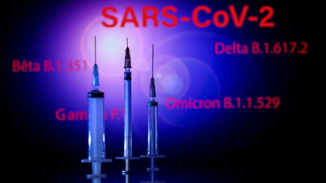 This photograph taken on December 2, 2021, shows a syringe and a screen displaying the SARS-Cov-2 mains variants : Alpha, Beta, Delta, Gamma and Omicron, in Toulouse. (AFP)