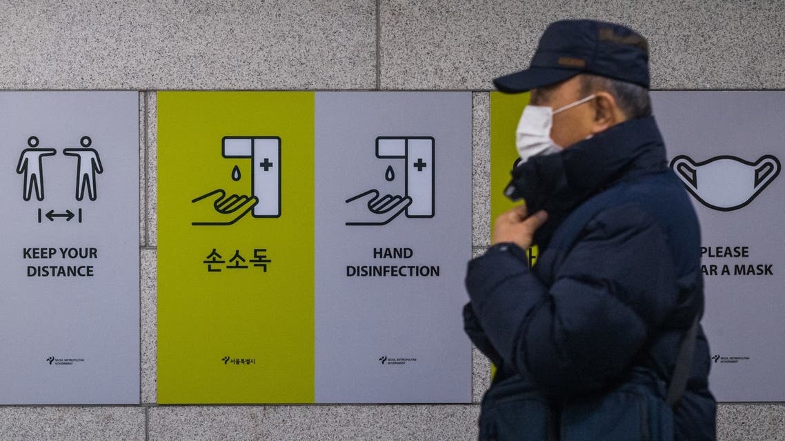 A commuter walks past information boards displayed to remind the public on how to help prevent the spread of the Covid-19 coronavirus in Seoul on December 1, 2021. (AFP)