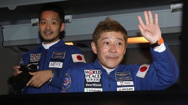 In this photo released by the Roscosmos Space Agency, spaceflight participants Yusaku Maezawa, right, and Yozo Hirano, left, of Japan, members of the main crew of the new Soyuz mission to the International Space Station (ISS) sit in a bus prior the launch at the Russian leased Baikonur cosmodrome, Kazakhstan, Wednesday, Dec. 8, 2021. (Pavel Kassin, Roscosmos Space Agency via AP)