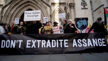 Supporters of WikiLeaks founder Julian Assange, hold placards outside the Royal Courts of Justice in London on December 10, 2021. (AFP/Niklas Halle'n/AFP)