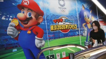 A shopper standing on an escalator passes by the Super Mario of Nintendo at an electronics store in Tokyo, on Nov. 2, 2020.  (AP)