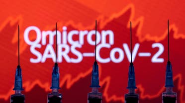 Syringes with needles are seen in front of a displayed stock graph and words Omicron SARS-CoV-2 in this illustration taken, November 27, 2021. (Reuters)