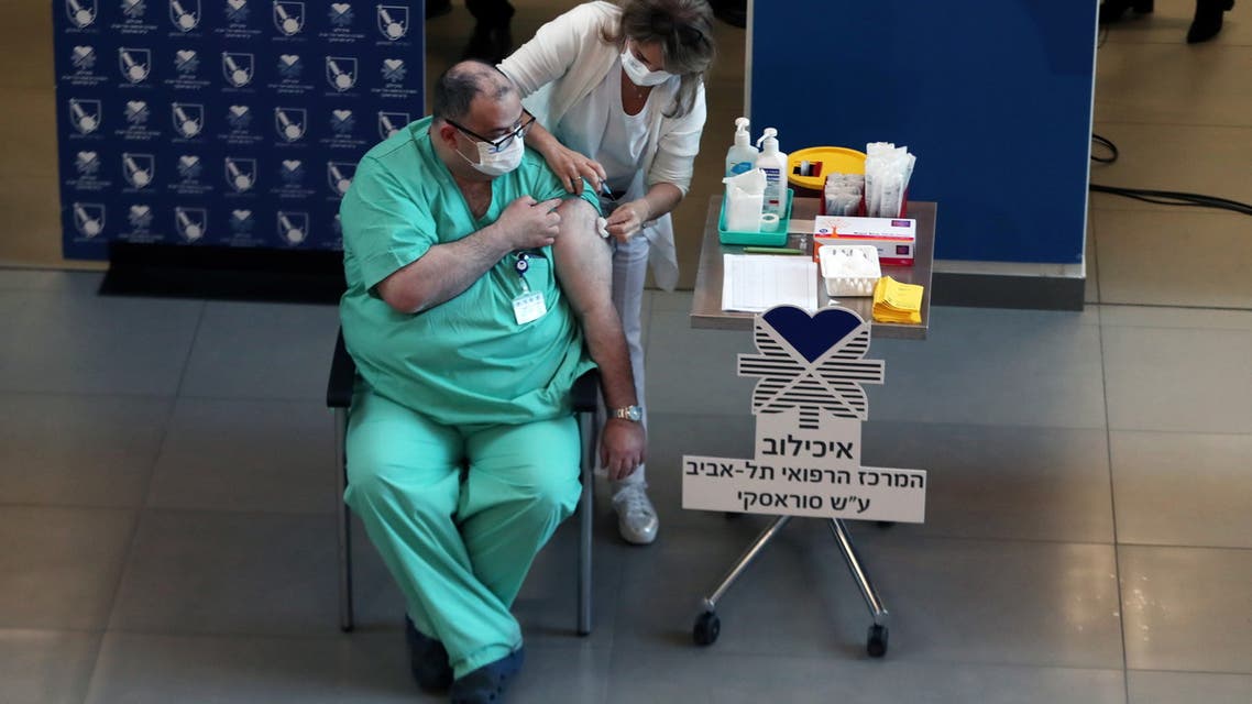 A medical worker vaccinates a medical team member against the coronavirus disease (COVID-19) as Israel kicks off a coronavirus vaccination drive, at Tel Aviv Sourasky Medical Center (Ichilov Hospital) in Tel Aviv, Israel December 20, 2020. REUTERS/Ronen Zvulun