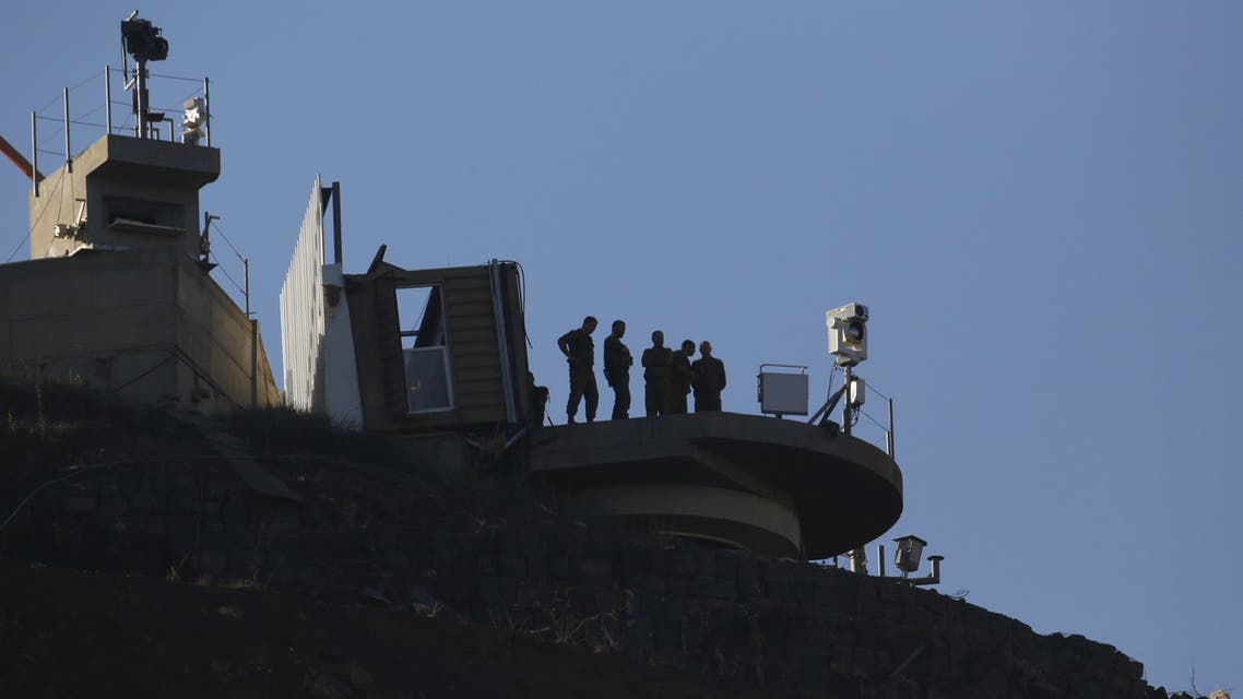 Israeli soldiers standing on top of an Israeli army base in the Israeli-annexed Syrian Golan Heights looks at a camp for displaced Syrians near the village of al-Rafid in the southern province of Quneitra, on July 2, 2018. (AFP)