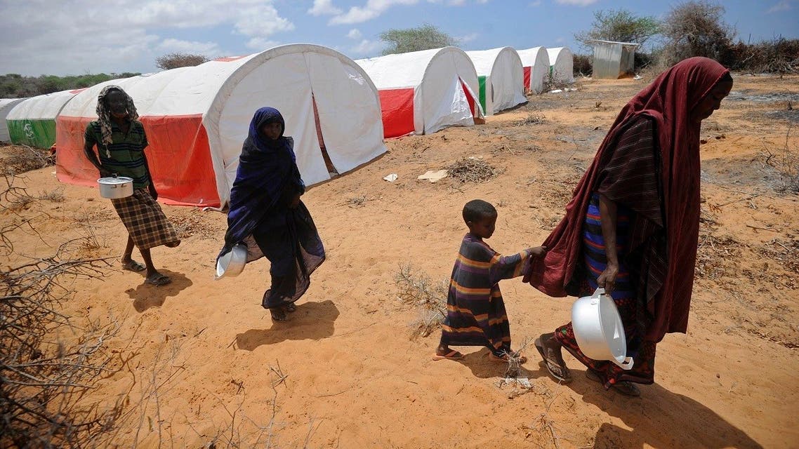 Newly displaced Somali women and children walk to a food distribution at the Kaxda district, outskirts of Mogadishu, on April 9, 2017. (AFP)