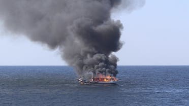 In this handout photograph from the US Navy, a traditional dhow sailing vessel suspected of smuggling drugs burns in the Gulf of Oman on Wednesday, December 15, 2021. (AP)