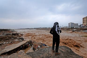A resident takes a video of the water levels of a river on the outskirts of Arbil, the capital of the northern Iraqi Kurdish autonomous region, on December 17, 2021, after flash floods caused by torrential rains left eight people dead. (AFP)