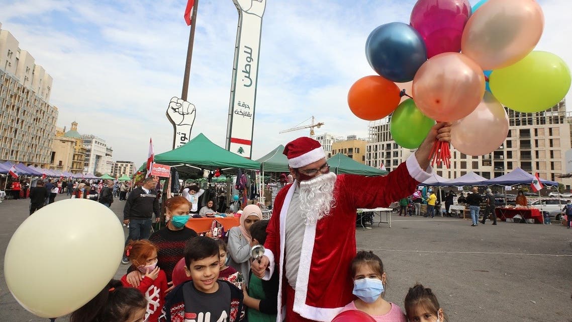 A Lebanese man wearing a Santa Claus outfit, entertains children at a Christmas market in Beirut. (File Photo: AFP)