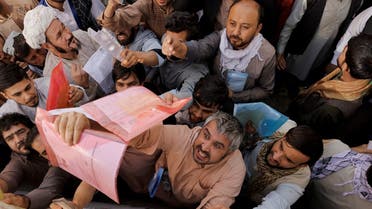 Afghans gather outside the passport office after Taliban officials announced they will start issuing passports to its citizens again, following months of delays that hampered attempts by those trying to flee the country after the Taliban seized control, in Kabul, Afghanistan, on October 6, 2021. (Reuters)