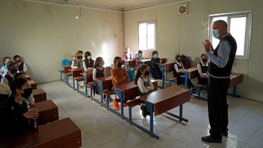 Girls sit in class on the first day of school in a Yazidi displacement camp in the Sharya area, some 15 Km from the northern city of Dohuk in the autonomous Iraqi Kurdistan region, on November 1, 2021. (AFP)