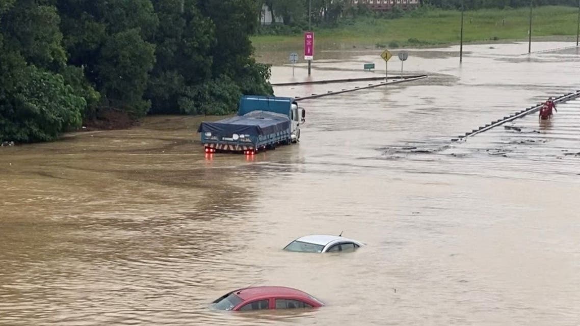 Partially submerged cars are seen on a flooded road in Shah Alam, Malaysia, on December 18, 2021, in still image obtained from social media video. (Reuters) 