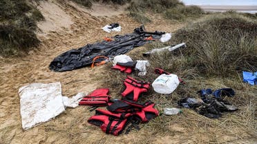 An inflatable boat, life vests and other remains left on a sand dune of the Wimereux beach, northern France, are pictured on December 20, 2021 as humanitarian association has filed manslaughter charges against high-ranking French and British officials for failing to help 27 people who drowned in November trying to cross the English Channel. (AFP)
