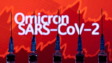 Syringes with needles are seen in front of a displayed stock graph and words Omicron SARS-CoV-2 in this illustration taken, November 27, 2021. (Reuters)