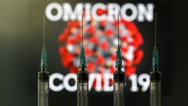 An illustration picture taken in London on December 2, 2021 shows four syringes and a screen displaying the word 'Omicron', the name of the new covid 19 variant, and an illustration of the virus. (AFP)