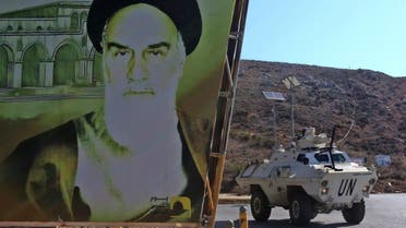 An armored UNIFIL personnel carrier is pictured next to a large poster of Iran’s Ayatollah Ruhollah Khomeini as it patrols along a road in southern Lebanese towns, Nov. 11, 2021. (AFP)