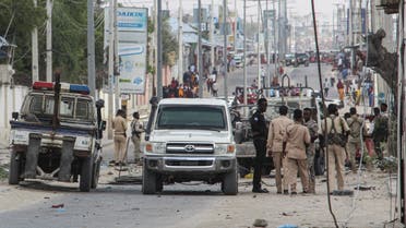 Police officers and people stand at the bomb explosion site in Mogadishu, Somalia, on November 25, 2021. (AFP)