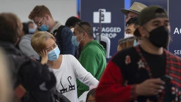 Travelers wait in line at Delta Airlines check-in at Los Angeles International Airport in Los Angeles, California, on December 24, 2021. (AFP)