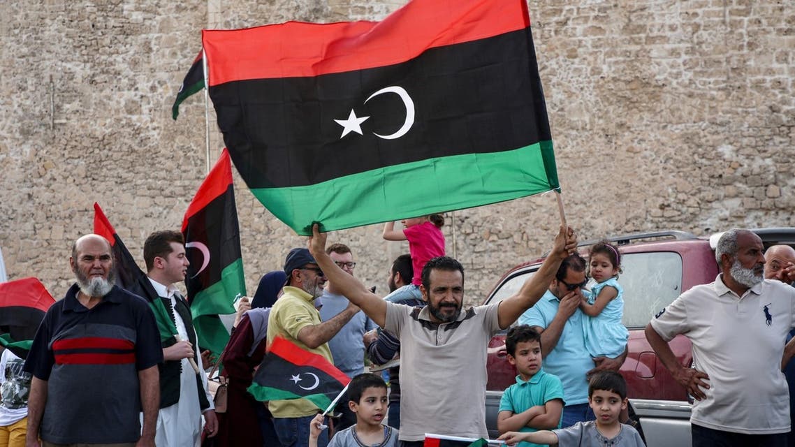 A man waves a Libyan national flag as people celebrate in the capital Tripoli on June 4, 2020, after the UN-recognised Government of National Accord (GNA) said it was back in full control of the capital and its suburbs. (AFP)