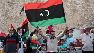 A man waves a Libyan national flag as people celebrate in the capital Tripoli on June 4, 2020, after the UN-recognised Government of National Accord (GNA) said it was back in full control of the capital and its suburbs. (AFP)