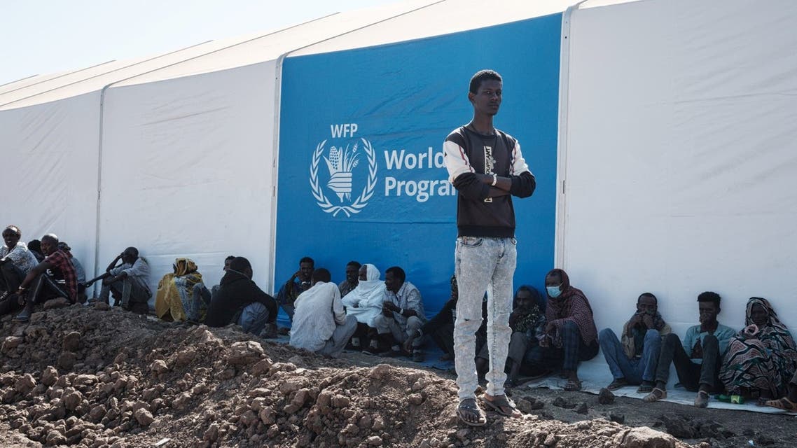 Ethiopian refugees who fled the Ethiopia's Tigray conflict wait for distribution of aid next to a warehouse erected by the World Food Programme (WFP) at Um Raquba refugee camp in Gedaref, eastern Sudan, on December 6, 2020. (AFP)