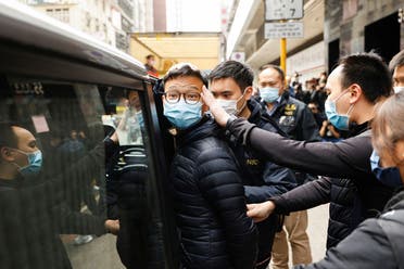 Stand News acting chief editor Patrick Lam, one of the six people arrested “for conspiracy to publish seditious publication” according to Hong Kong’s Police National Security Department, is escorted by police as they leave after the police searched his office in Hong Kong, China, on December 29, 2021. (Reuters)