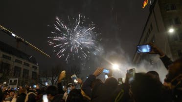 Spectators at the boulevard Unter den Linden watch fireworks as they celebrate the New Year near the Brandenburg Gate in Berlin, Germany, on Jan. 1, 2022. (AP)