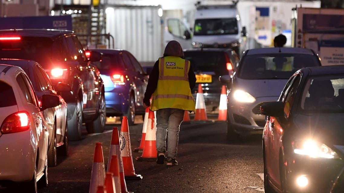 Members of the public travel in their cars as they arrive at, and depart from, a Covid-19 drive-in coronavirus testing centre in London on December 18, 2021. (AFP)