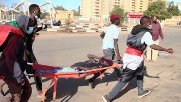 Sudanese protesters carry a wounded youth on a stretcher, during a demonstration against the October 25 coup, in the capital Khartoum, on January 2, 2022. (AFP)