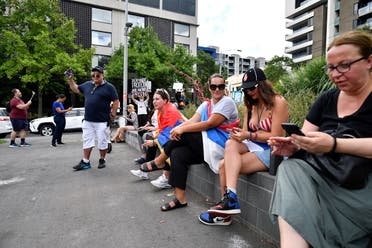 Supporters sit outside the Park Hotel, believed to be holding Serbian tennis player Novak Djokovic in Melbourne, Australia, on January 6, 2022. (Reuters)