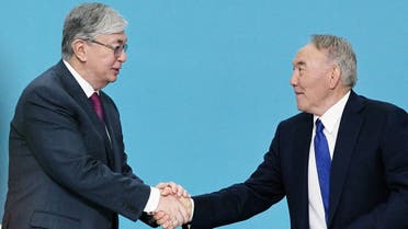 In this file photo taken on April 23, 2019 Former Kazakh president Nursultan Nazarbayev shakes hands with President Kassym-Jomart Tokayev during a congress of the ruling Nur Otan party in Nur-Sultan. (AFP)