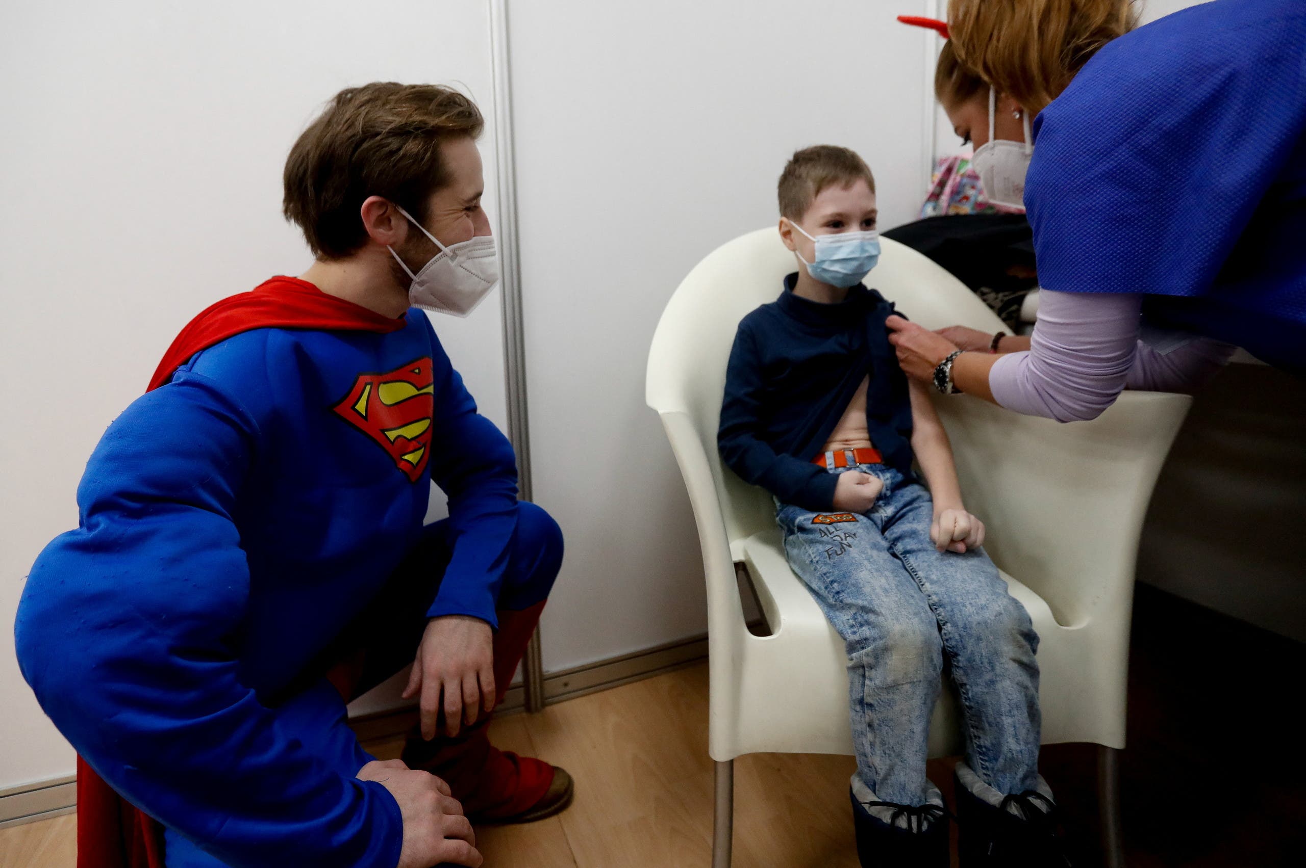 سوبرمان يراقب أحد الأطفال خلال تلقيه اللقاح