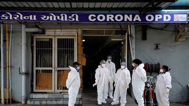 Healthcare workers wearing personal protective equipment (PPE) stand at the entrance of a coronavirus hospital in Ahmedabad, India, on January 7, 2022. (Reuters)