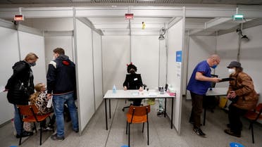 A medical staff member wearing a costume looks at a child who receives a shot of the coronavirus disease (COVID-19) vaccine at a mass vaccination center in Prague, Czech Republic, January 8, 2022. REUTERS/David W Cerny