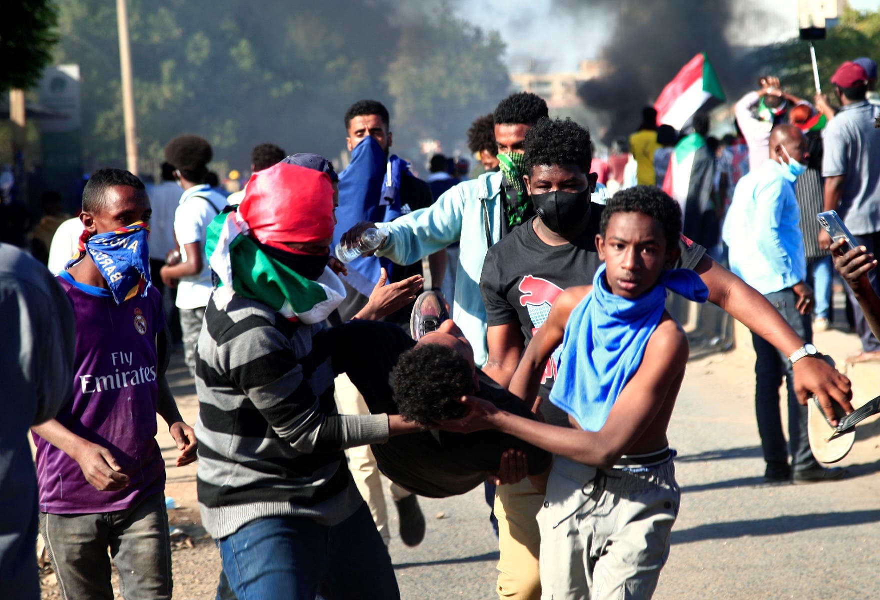 Sudanese demonstrators carry a wounded man during a protest demanding civilian rule in the Street 40 of the Sudanese capital's twin city of Omdurman on January 4, 2022. (AFP)