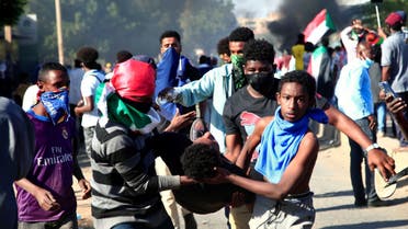 Sudanese demonstrators carry a wounded man during a protest demanding civilian rule in the Street 40 of the Sudanese capital's twin city of Omdurman on January 4, 2022. (AFP)