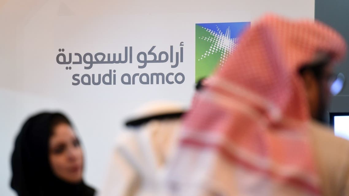 Saudi and Foreign investors stand in front of the logo of Saudi state oil giant Aramco during the 10th Global Competitiveness Forum on January 25, 2016, in the capital Riyadh. (AFP)