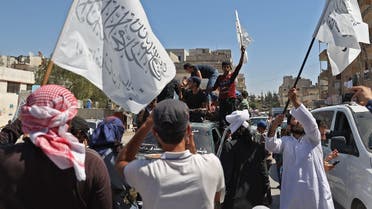 Members of Syria's Hayat Tahrir al-Sham (HTS) alliance, led by al-Qaeda's former Syria affiliate, parade with their flags and those of the Taliban, Aug. 20, 2021. (AFP)