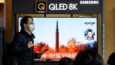 A man walks past a television screen showing a news broadcast with file footage of a North Korean missile test, at a railway station in Seoul on Jan. 11, 2022. (AFP)