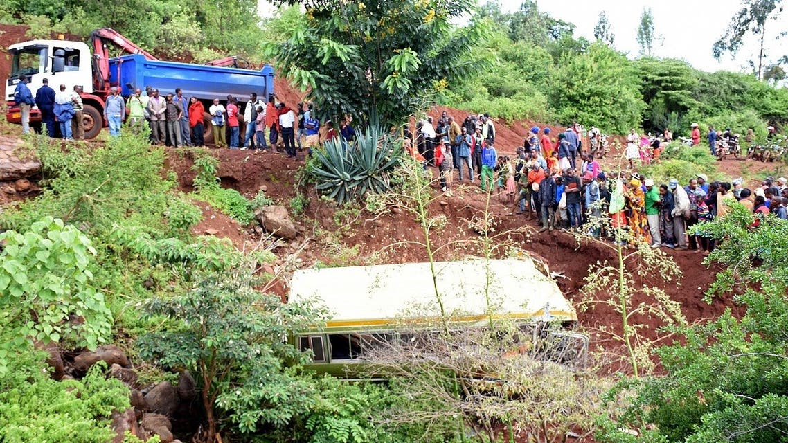 A file photo shows people look at the wreckage of a bus that had been transporting primary school pupils from Arusha to Karatu in Tanzania before plunging into a gorge, killing at least 29 children, two teachers and the driver, on May 6, 2017. (AFP)